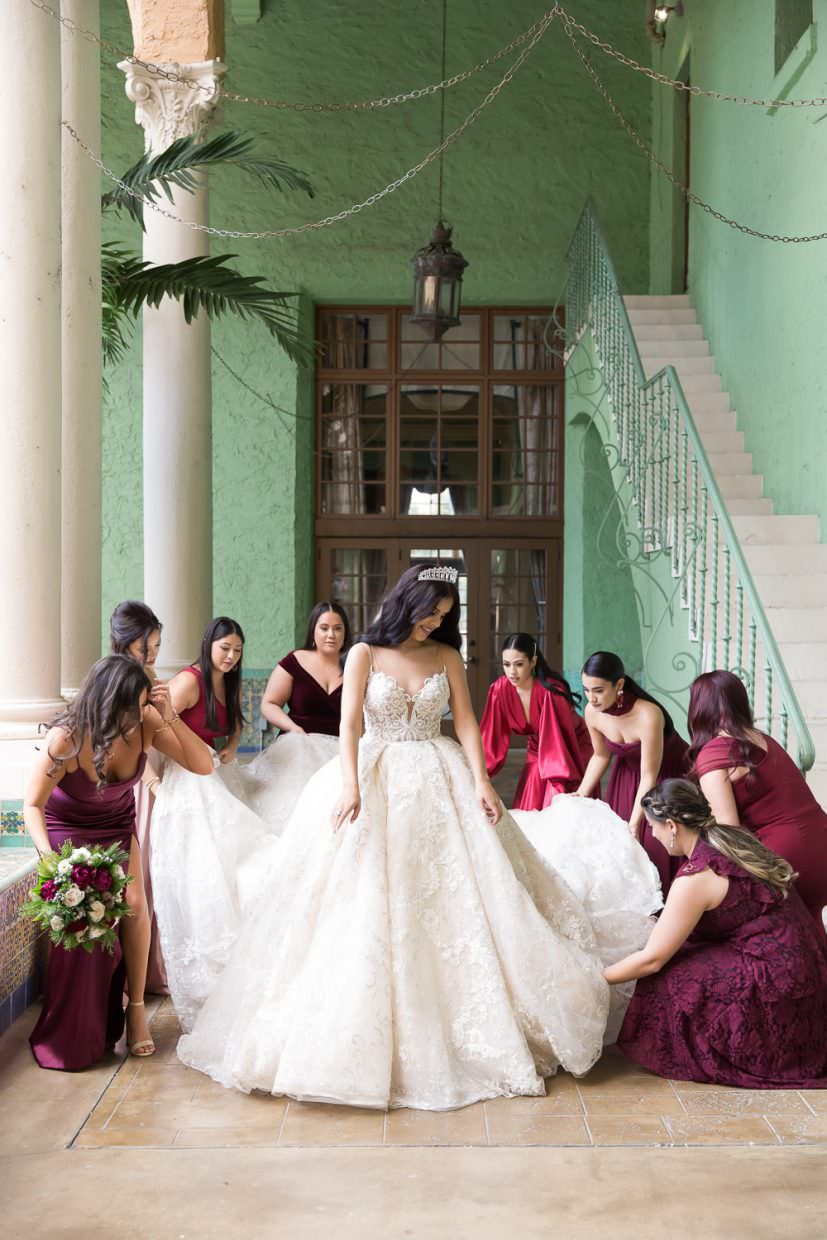 Bridesmaids help a bride with her gown at the Biltmore Hotel in Coral Gables.